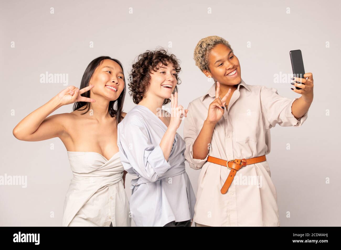 Junge asiatische, afrikanische und kaukasische Frauen in Smart Casualwear machen Selfie Stockfoto