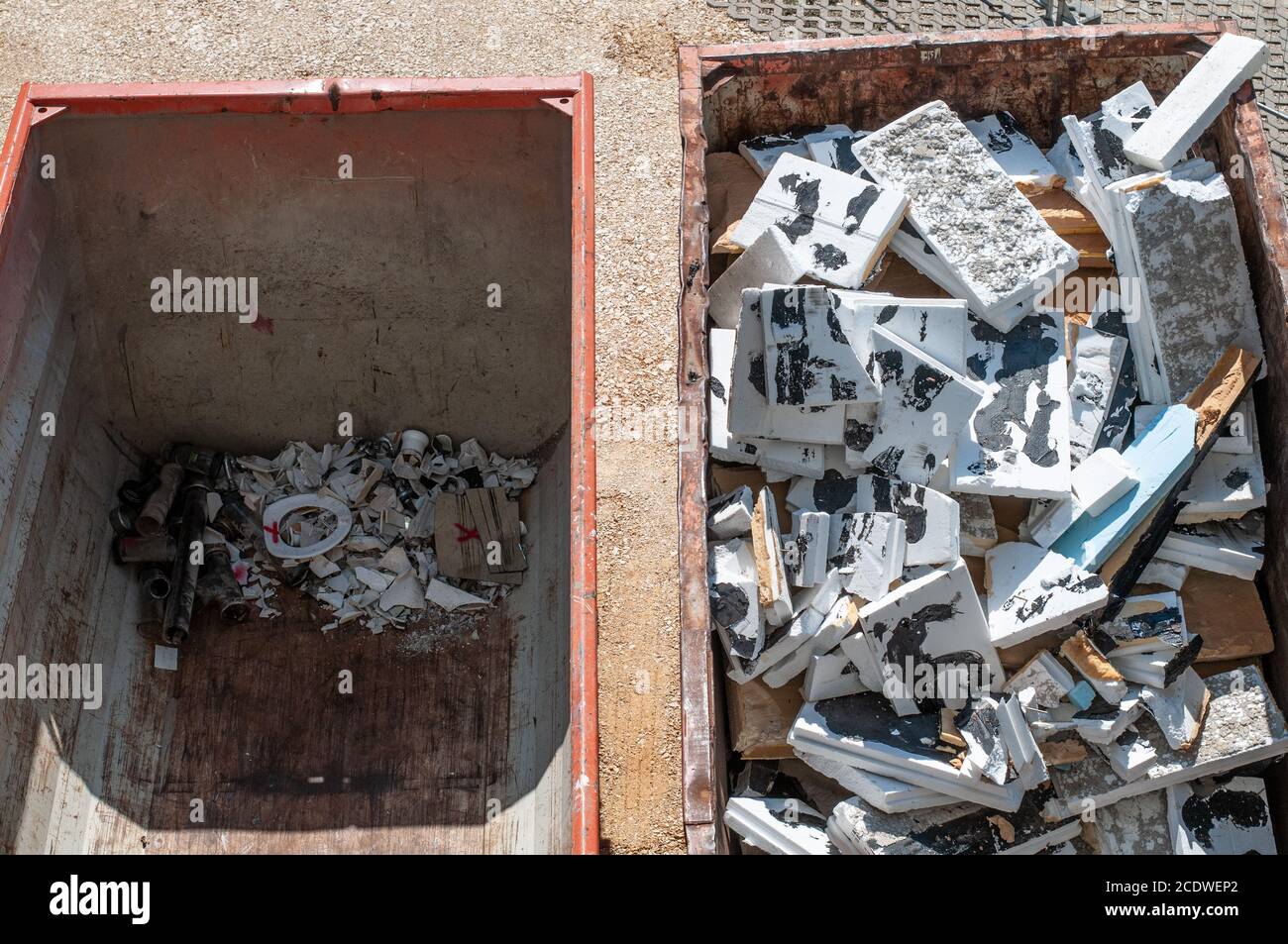 Große Metallabfallbehälter auf einer Baustelle gefüllt mit Entfernte Isolierung und Sanitärmaterialien Stockfoto