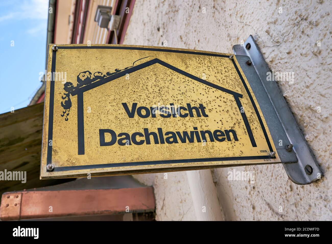 Schild mit der Aufschrift Vorsicht Dach Lawinen auf einem Haus In