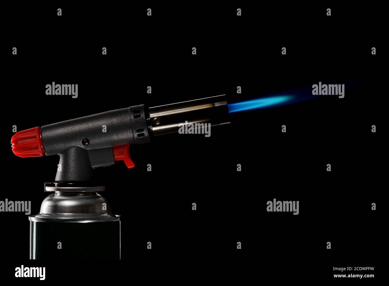 Gasbrenner mit brennender Flamme auf schwarzem Hintergrund Stockfoto