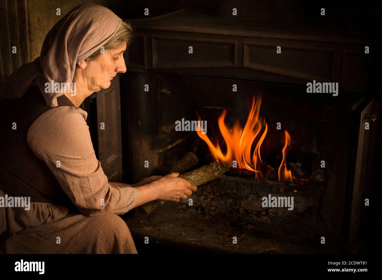 Renaissance alten Meister Porträt einer Bauernfrau Holz hinzufügen Zu einem brennenden Feuer Stockfoto