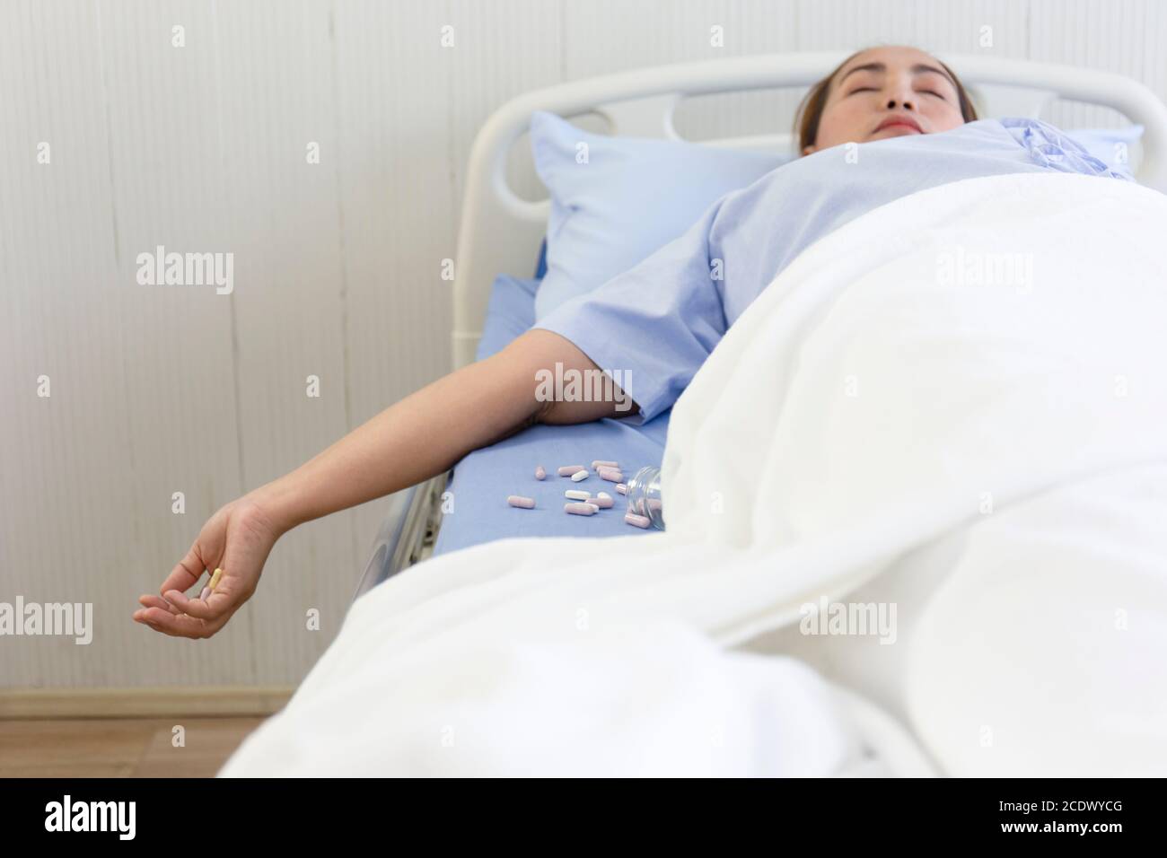 Weibliche Patienten im Krankenhaus nehmen eine Überdosis und verlieren das Bewusstsein auf dem Bett. Stockfoto