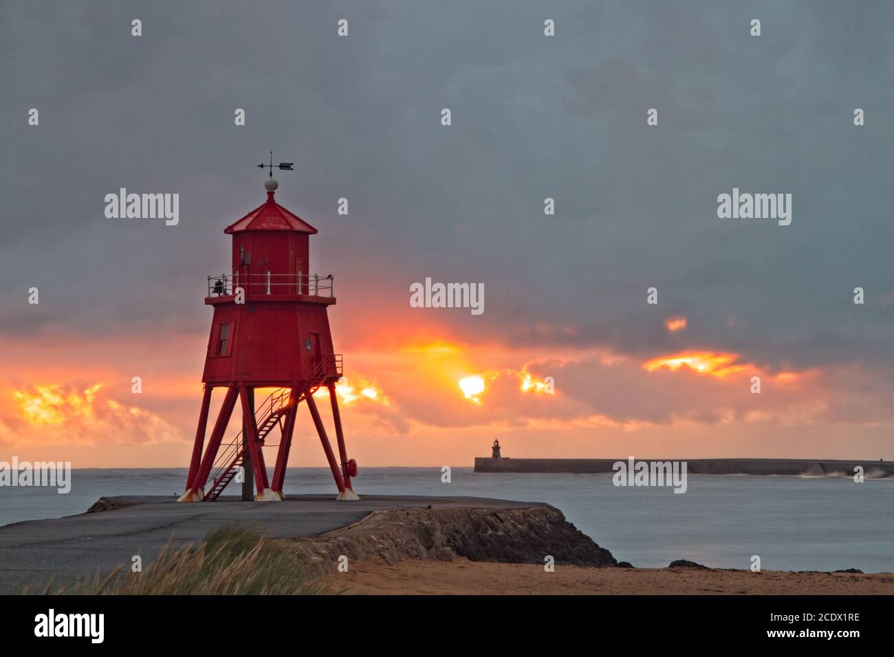 Die rote Herde Groyne Leuchtturm in der Mündung des Flusses Tyne in South Shields bei Sonnenaufgang gefangen. Stockfoto