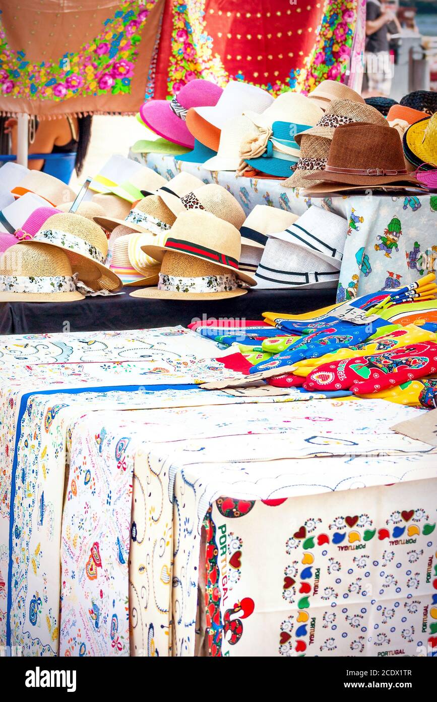Stand mit Hüten, bestickten Tischdecken und anderen Textilien als Souvenir aus Portugal Stockfoto
