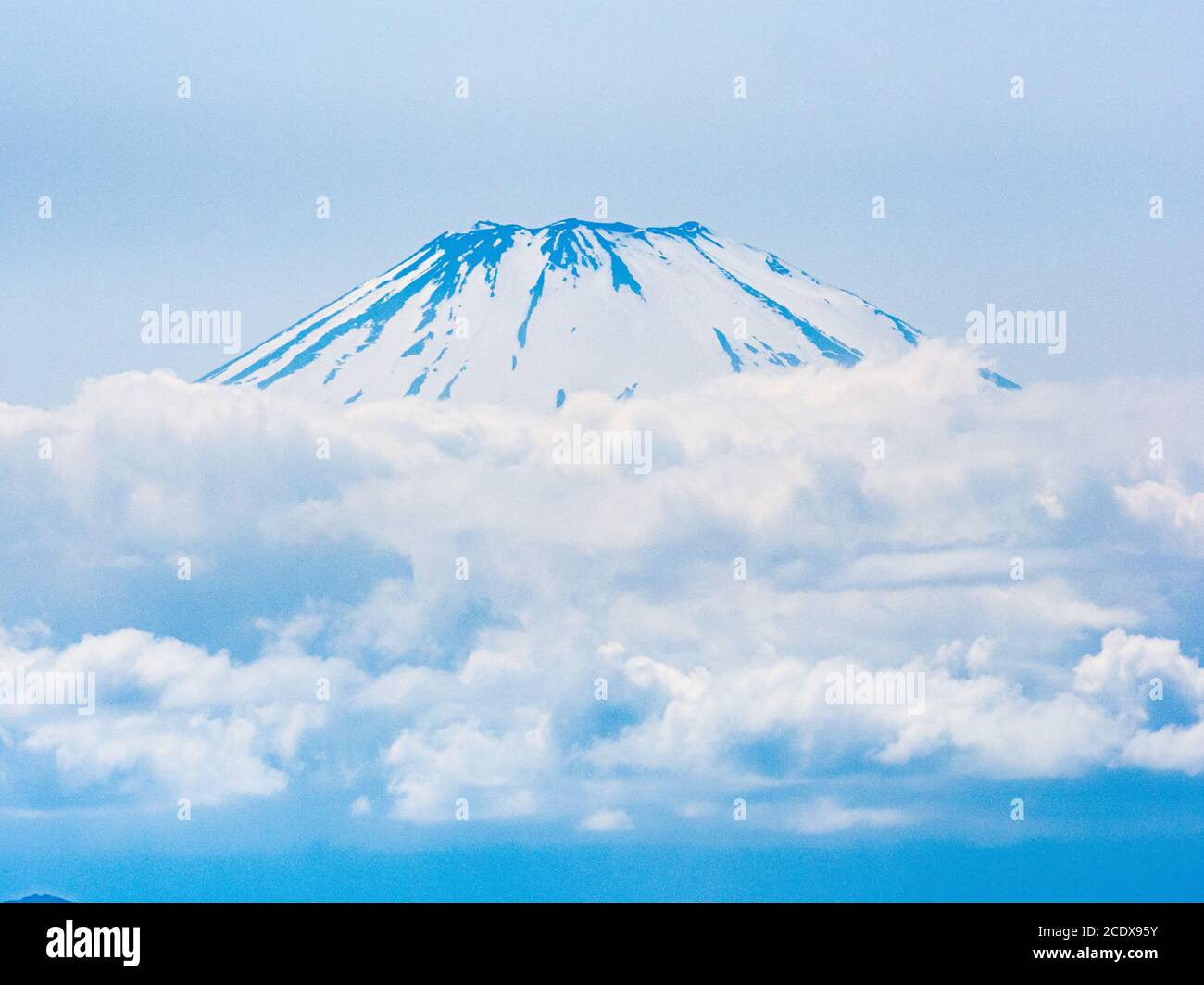 Mt. Fuji steigt an einem Frühlingsnachmittag über den Wolken auf, wie man von Enoshima aus gesehen hat. Stockfoto