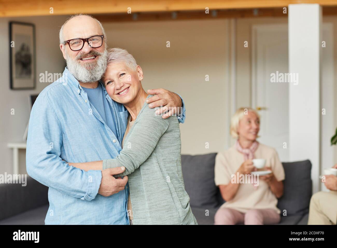Portrait von glücklichen älteren Paar stehend umarmen einander und Lächelnd bei der Kamera zu Hause Stockfoto
