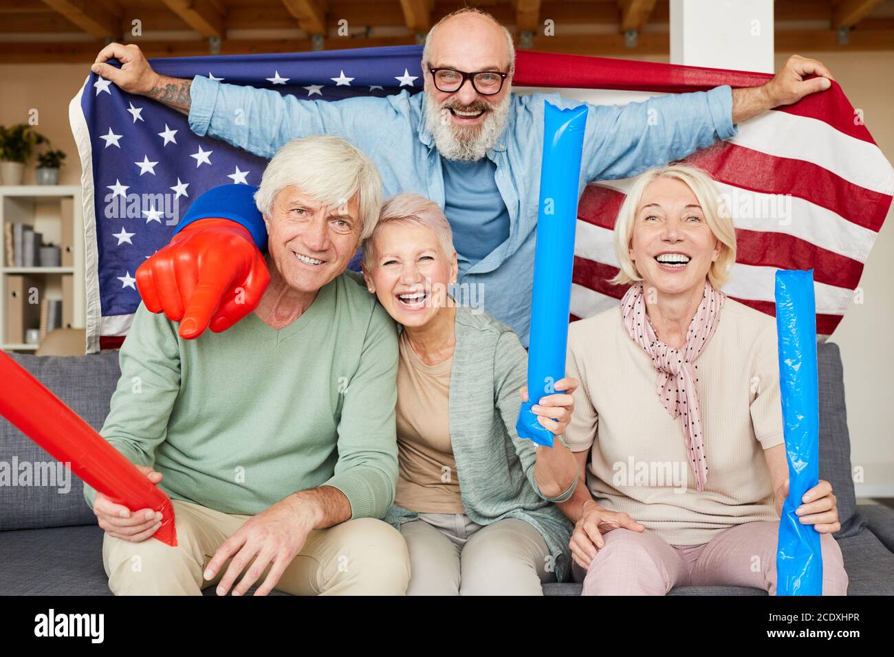 Portrait von aufgeregten älteren Freunden, die gemeinsam für ihre Amerikaner jubeln Fußballmannschaft zu Hause Stockfoto