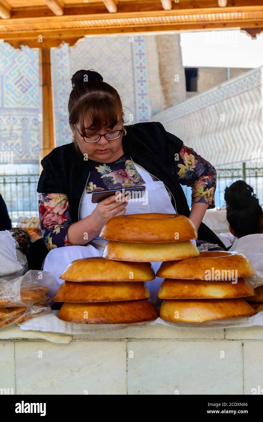 Frau, die Brot auf dem Markt verkauft. Samarkand, Usbekistan Stockfoto