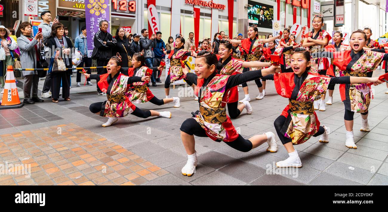 Japanisches Team von yosakoi-Kindertänzern mit Naruko, Holzklatschern und Tanz in der Einkaufspassage Sun Road während des Kyusyu Gassai Festivals. Stockfoto