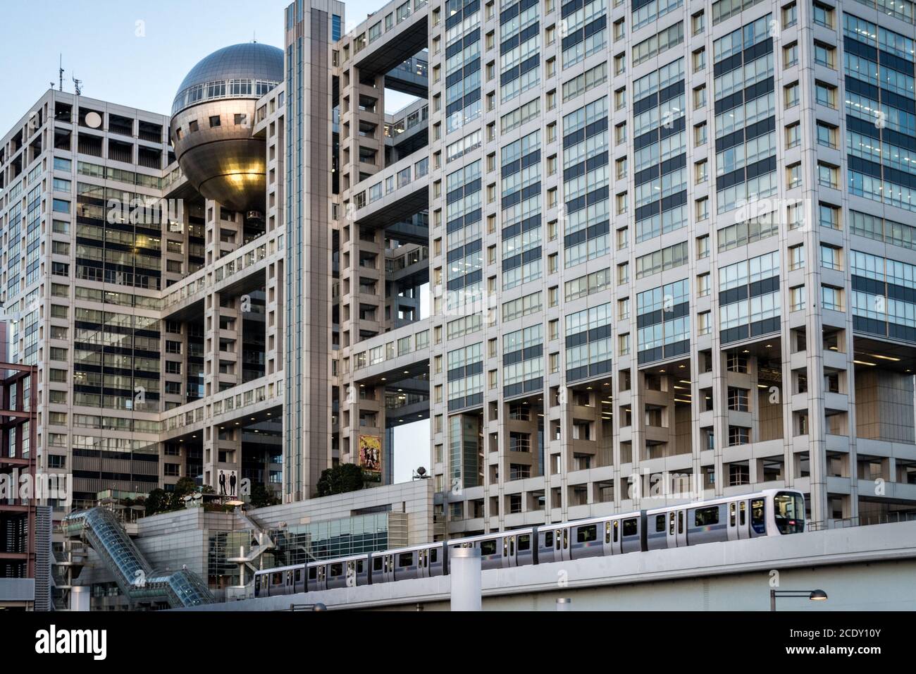 Odaiba, Tokyo, Japan - Fuji Television Headquarters Building und Yurikamome City Train, die vor dem einzigartig gestalteten Gebäude fahren. Stockfoto
