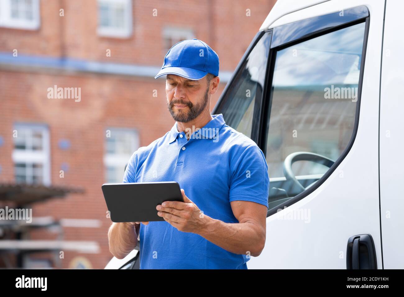 Delivery Man In Der Nähe Von Lkw Oder Van Mit Tablet Stockfoto