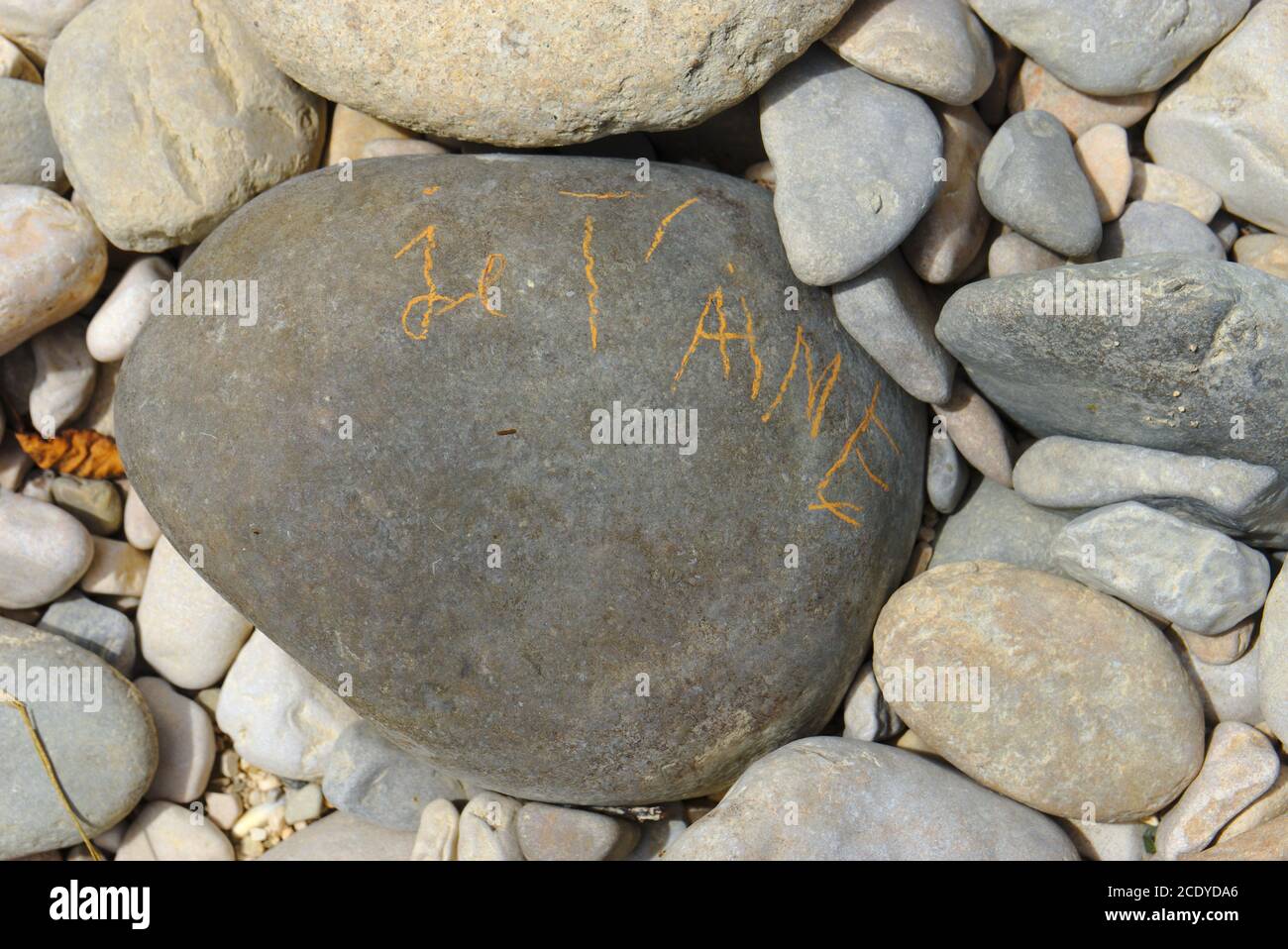 Inschrift 'I love you' geschrieben mit gelber Kreide auf einem Kieselstein Stockfoto