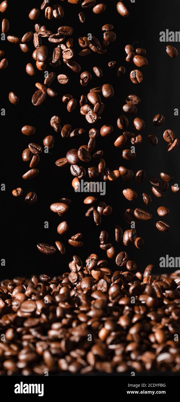 Fallende Kaffeebohnen auf schwarzem Hintergrund isoliert Stockfoto
