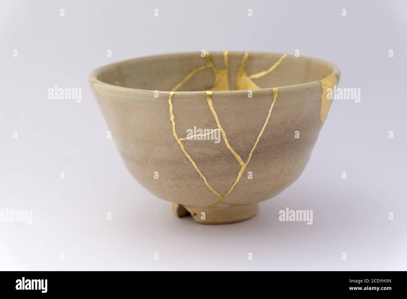 Kintsugi beige Schüssel. Gold Risse Restaurierung auf alten japanischen Keramik. Stockfoto