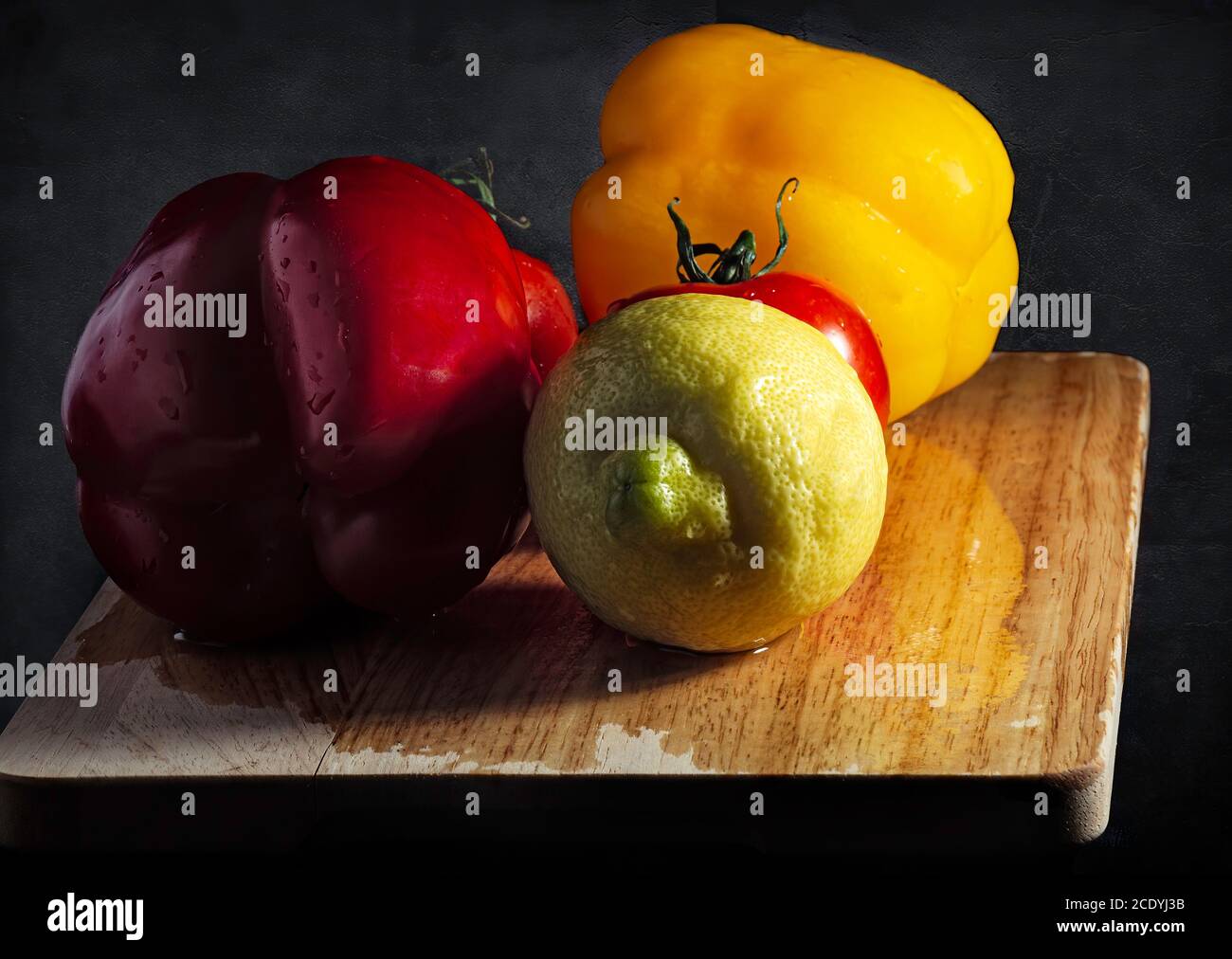 Gemüse und Obst über einem rustikalen Schneidebrett in Low Tastenbeleuchtung Stockfoto