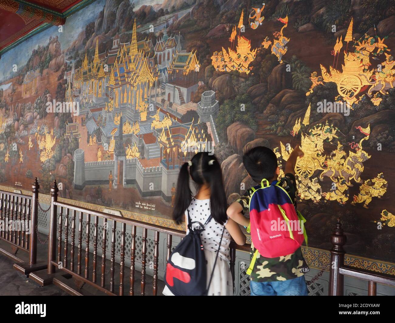 Zwei asiatische Kinder betrachten ein Wandbild im Grand Palace, Bangkok, Thailand Stockfoto