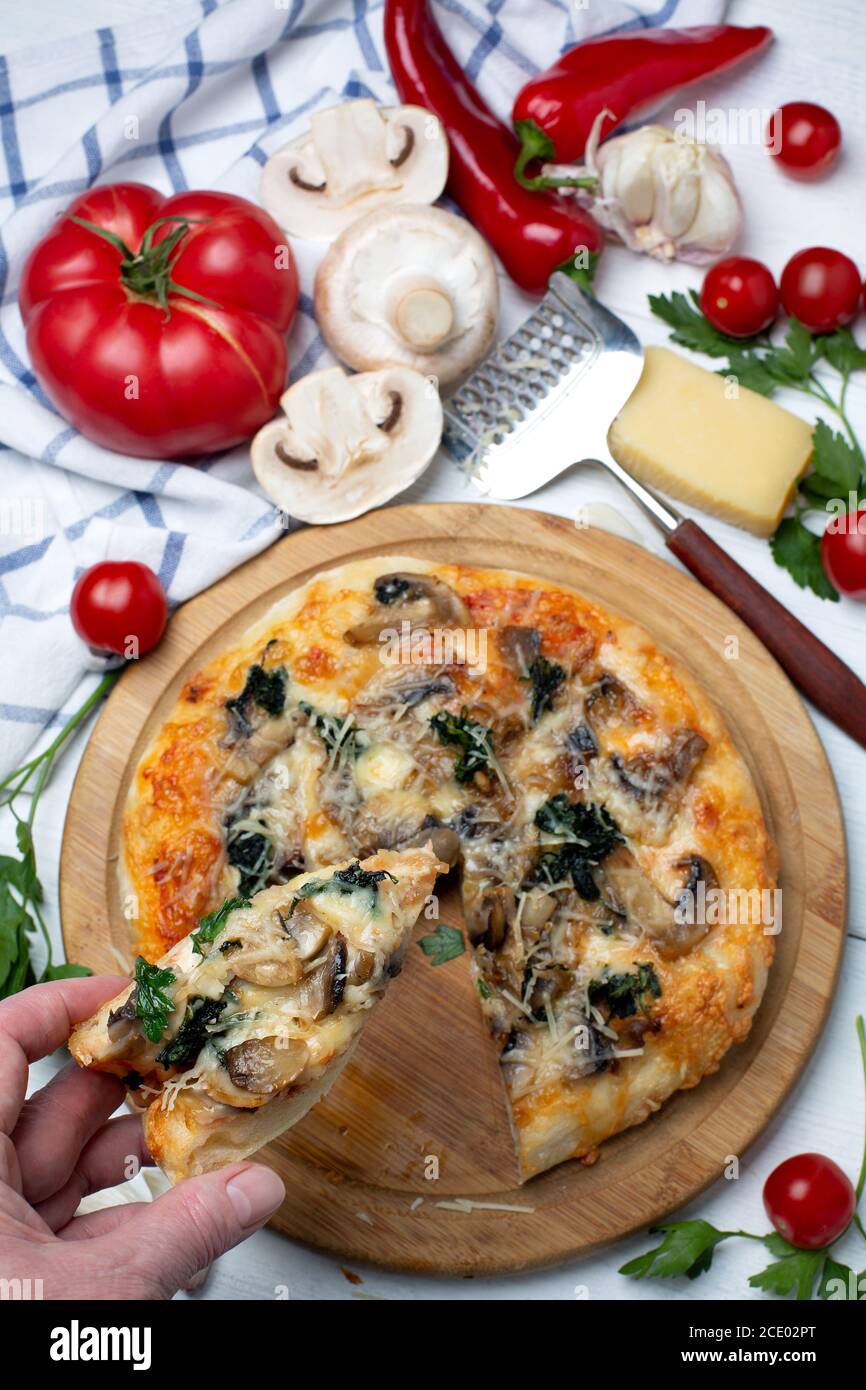 Pizza-Scheibe mit Pilzen, Spinat und Käse. Stockfoto