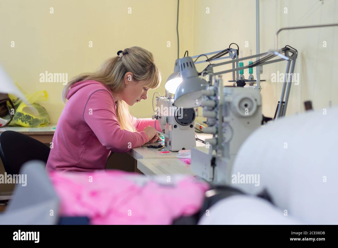 Arbeiter in der Nähwerkstatt näht auf einer professionellen Nähmaschine Stockfoto