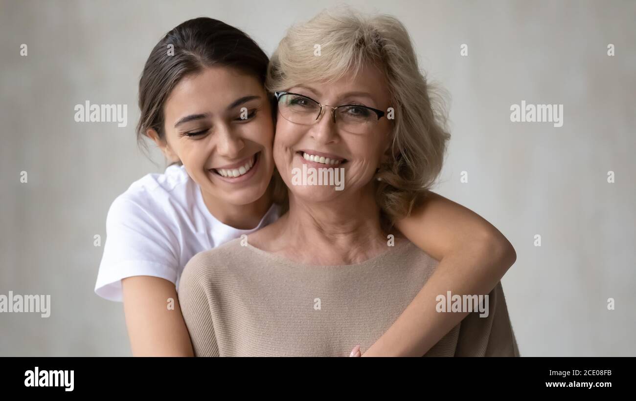 Aufrichtiges Lächeln junge Frau kuscheln glücklich mittleren Alters 60s Mutter. Stockfoto