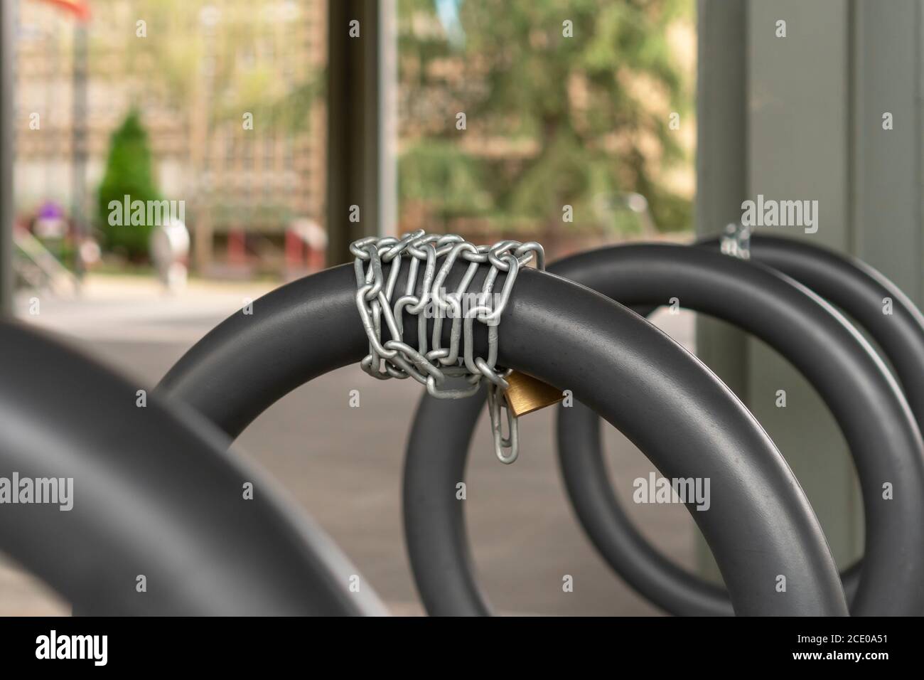 Kettenschloss aus der Nähe auf einem Fahrradparkplatz Stockfoto