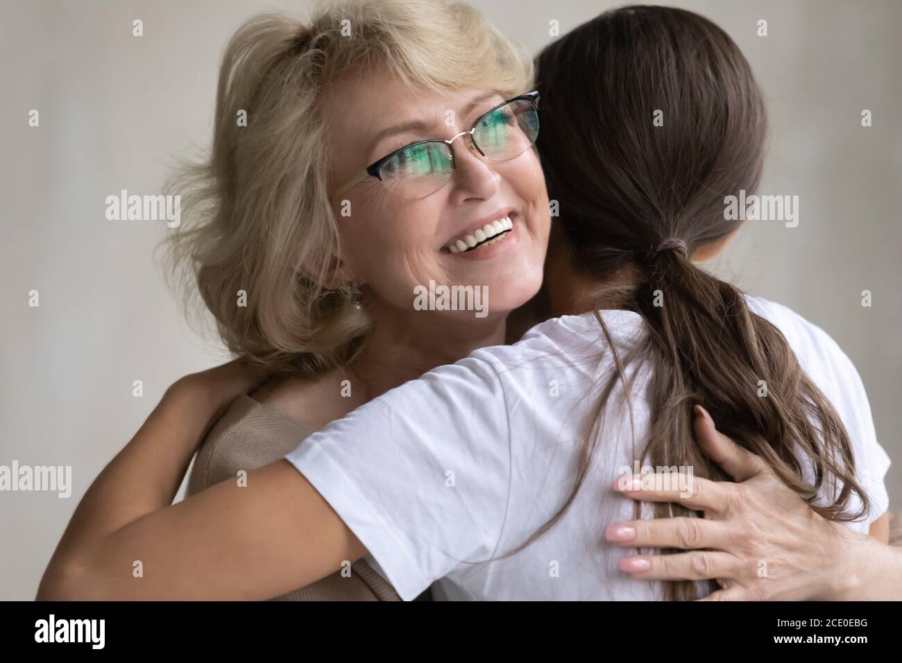 Dankbar aufrichtig glücklich 60s Mutter kuscheln liebevoll aufgewachsen Tochter. Stockfoto