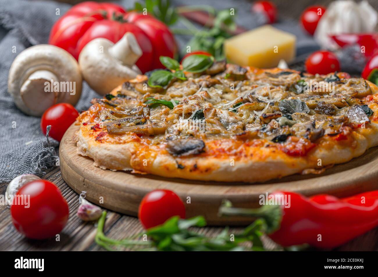Hausgemachte Pizza mit Tomaten, Spinat und Pilzen. Stockfoto