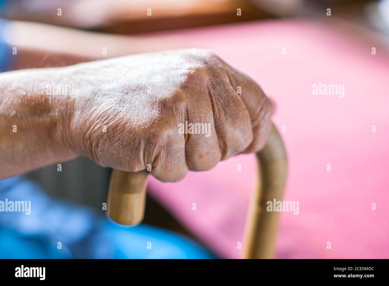 Die Hand älterer Menschen hält einen Gehstock Stockfoto