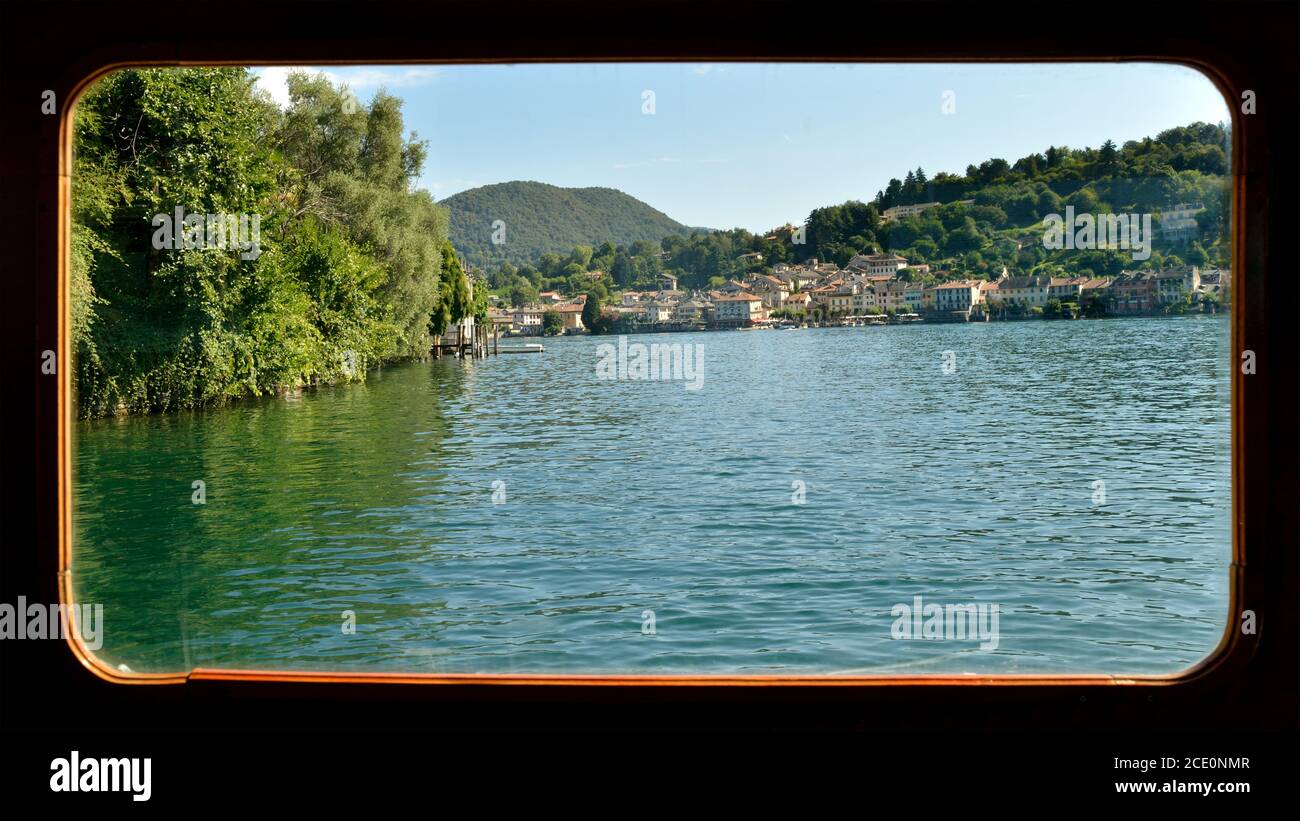 Blick auf Orta San Giulio, vom Bootsfenster - Ortasee, Lombardei, Italien Stockfoto