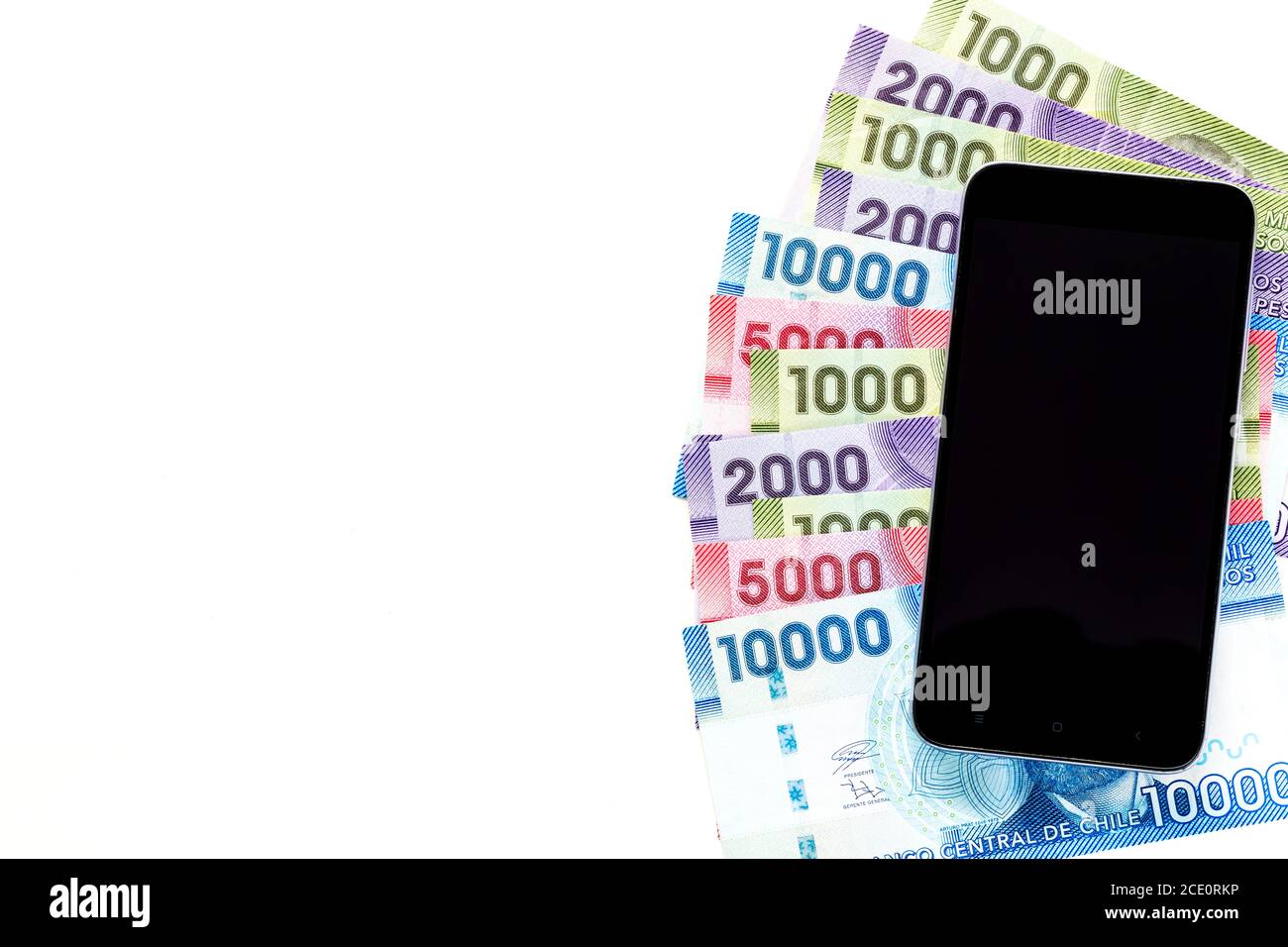 Chile Geld, Banknoten liegen auf dem Tisch zusammen mit dem Handy, verschiedene Stückelungen, Weißer Hintergrund, Platz für Text Stockfoto
