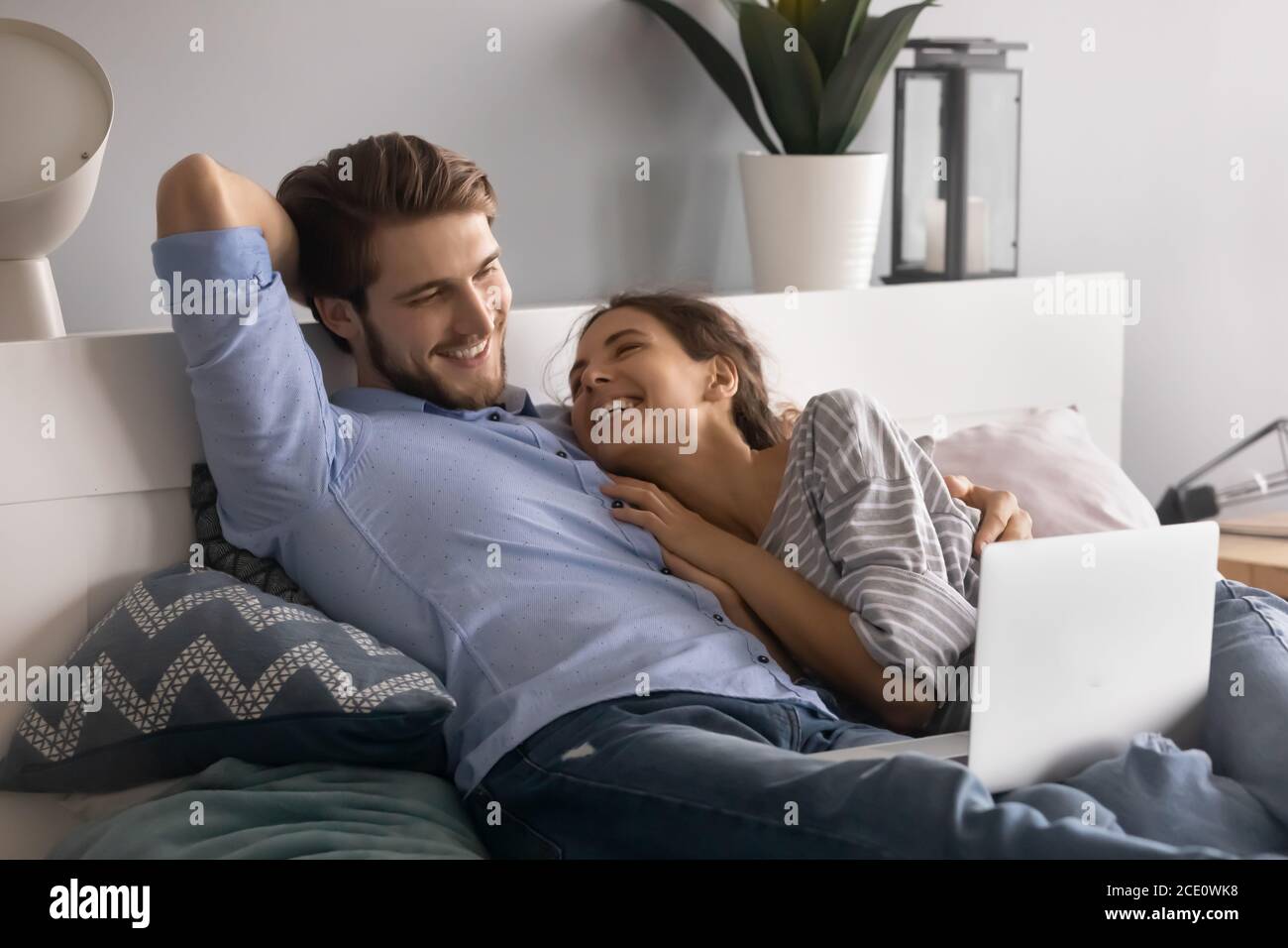 Emotionales junges entspanntes Familienpaar, das beim lustigen Film lacht. Stockfoto
