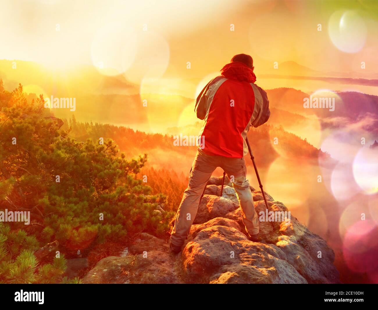 Filmeffekt. Glücklich Foto-Enthusiasten genießen Sie die Fotografie von Herbst Tagesanbruch in der Natur auf Felsen. Traumhafte Landschaft Stockfoto