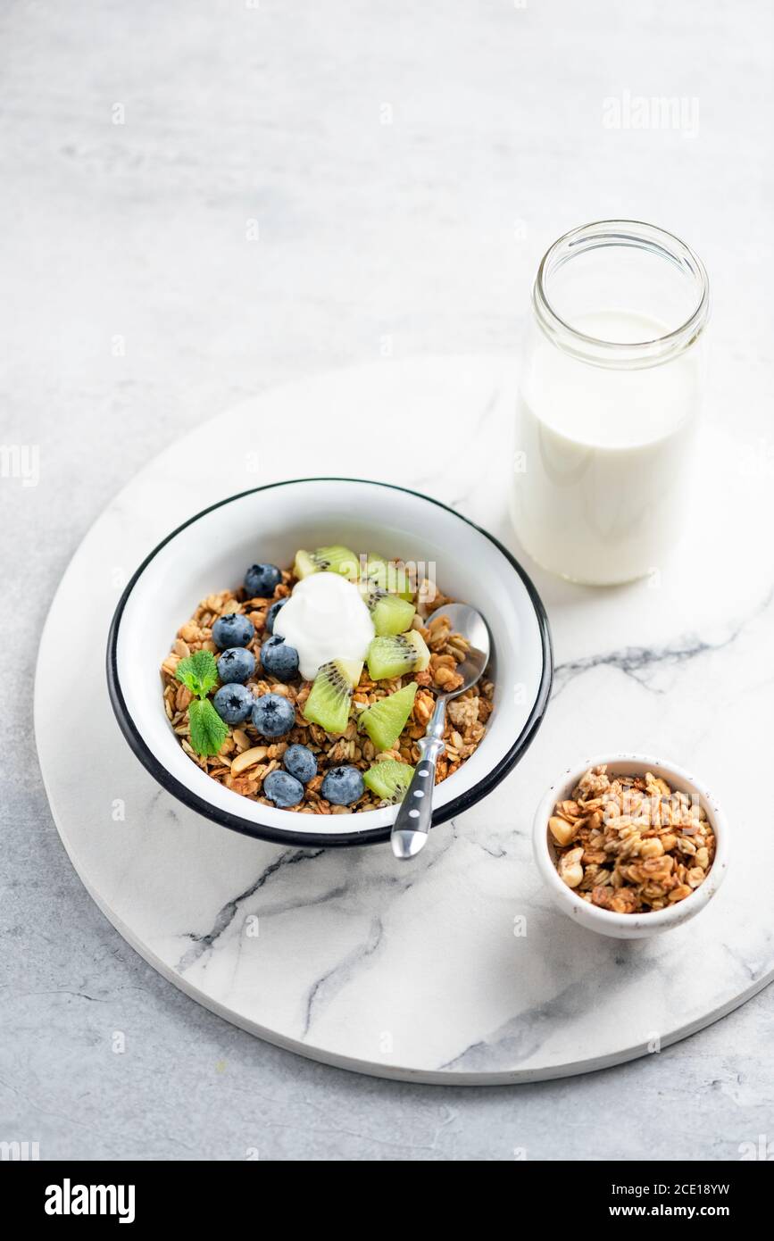 Schüssel Müsli mit Heidelbeeren, Kiwi und Joghurt. Gesundes Frühstück Essen, sauberes Essen Konzept Stockfoto