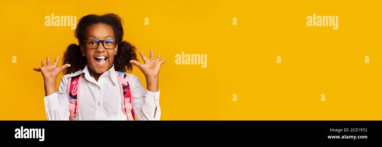 Glücklich Afrikanisch Amerikanisch Schulmädchen Schreiend Über Gelb Studio Hintergrund Stockfoto