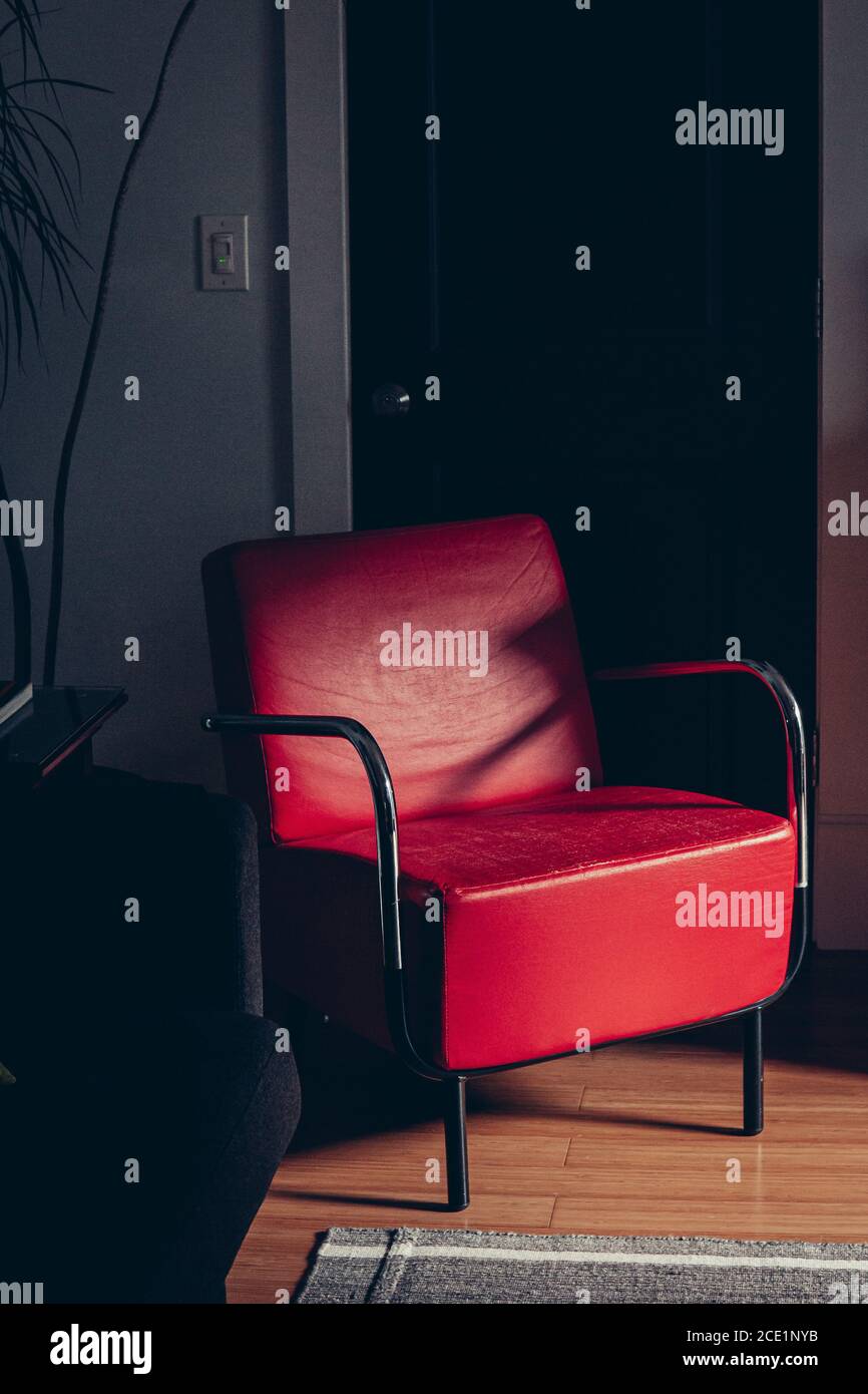 Roter Stuhl in der Ecke des Zimmers Stockfoto