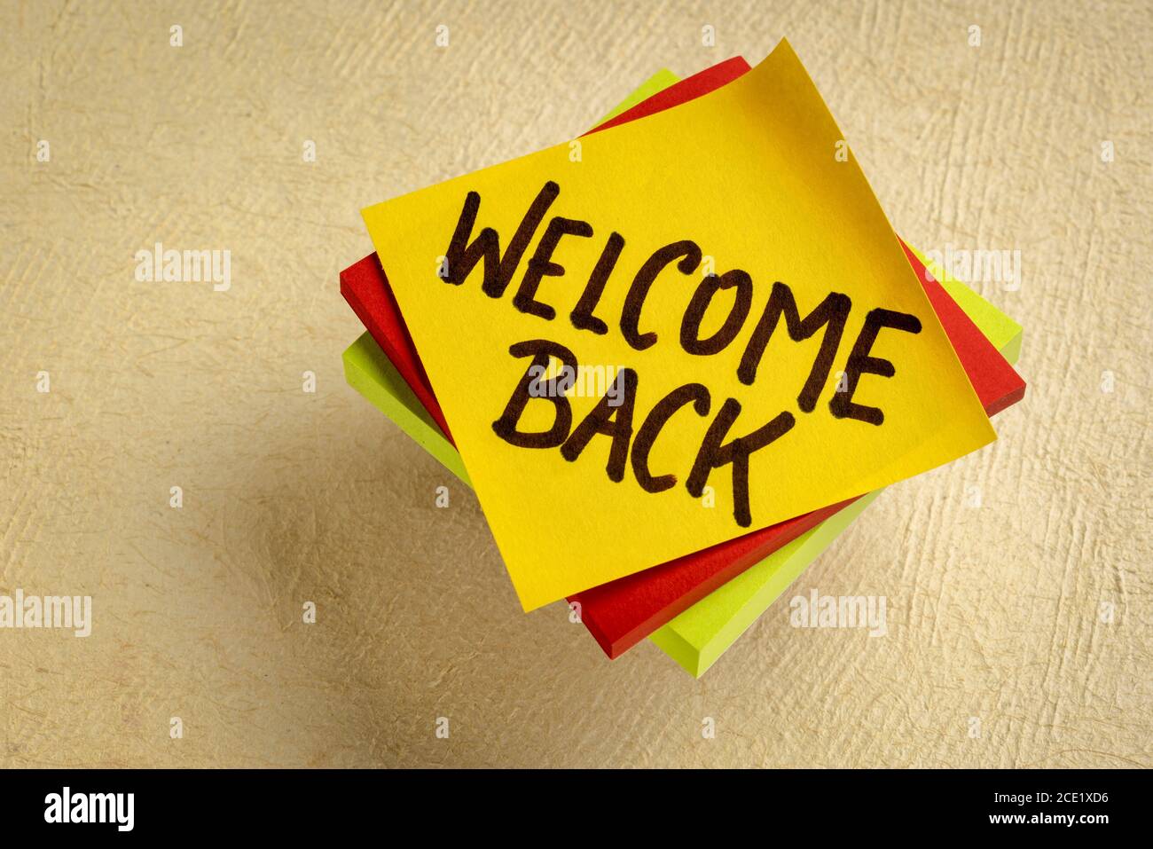 Willkommen zurück - Handschrift auf einer Haftnotiz, Grüße und Business Wiedereröffnung Konzept Stockfoto