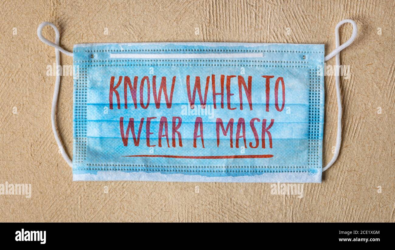Wissen, wann man eine Maske tragen - Text auf einer Einweg-Gesichtsmaske , Coronavirus covid-19 Pandemie und Public Health Konzept Stockfoto