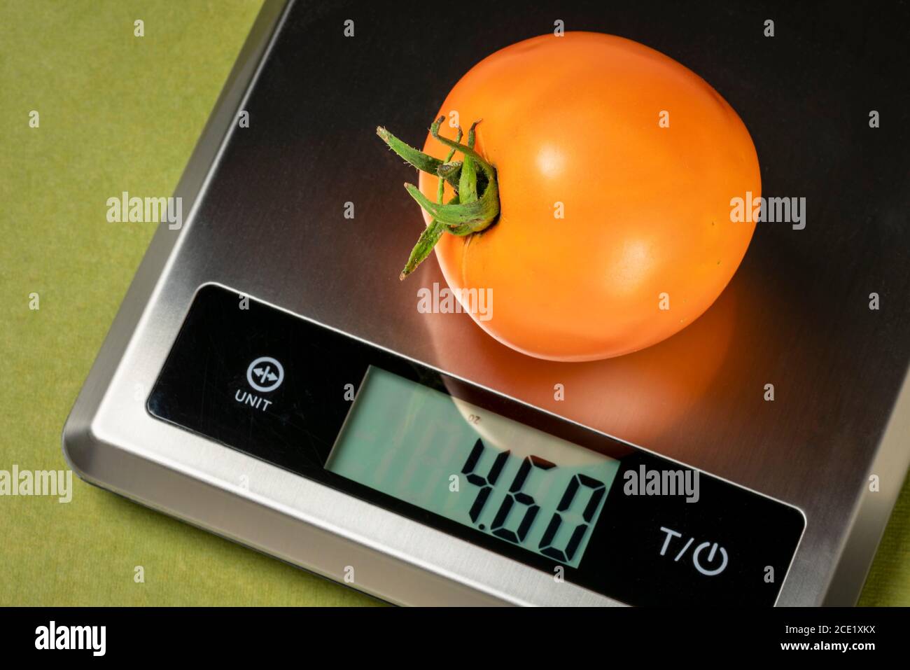 Frische gelbe Tomate auf einer digitalen Ernährung Diät Skala, gesunde Ernährung Konzept Stockfoto