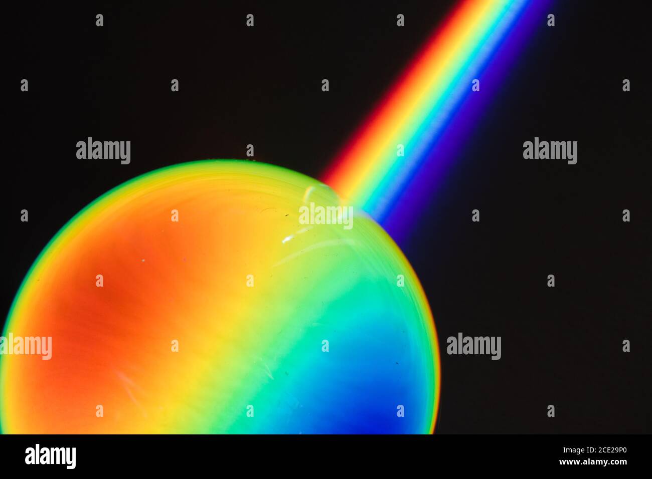 Farben des Regenbogenprodukts des gebrochenen Lichts, das das Spektrum des Lichts zeigt, das von einem sphärischen Glasobjekt Physik und Optik gebogen wird Stockfoto