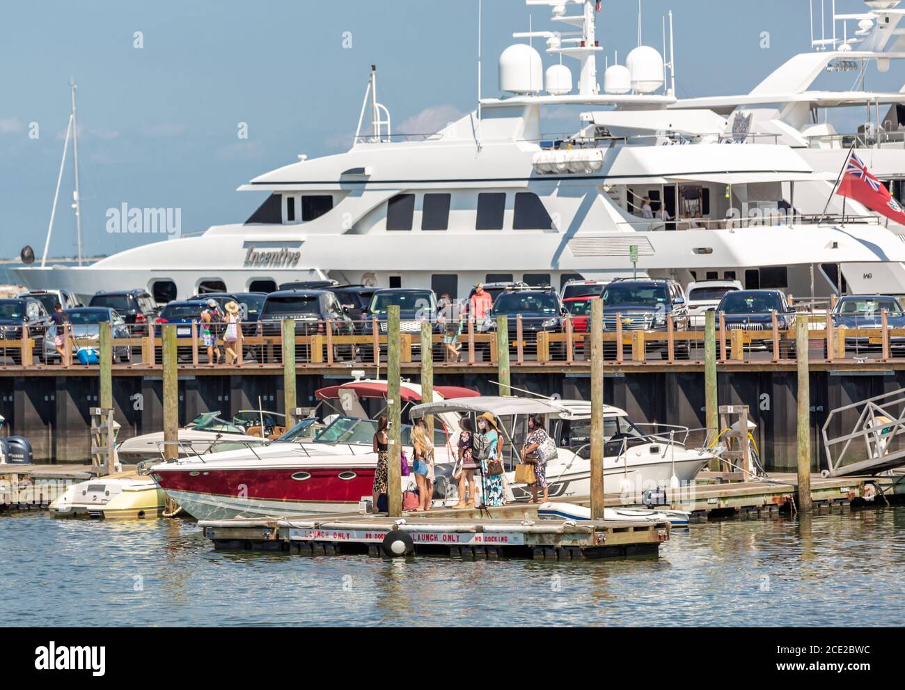 Gruppe von Frauen mit Gesichtsmasken warten auf ein Boot auf Long Wharf, Sag Harbor, NY Stockfoto