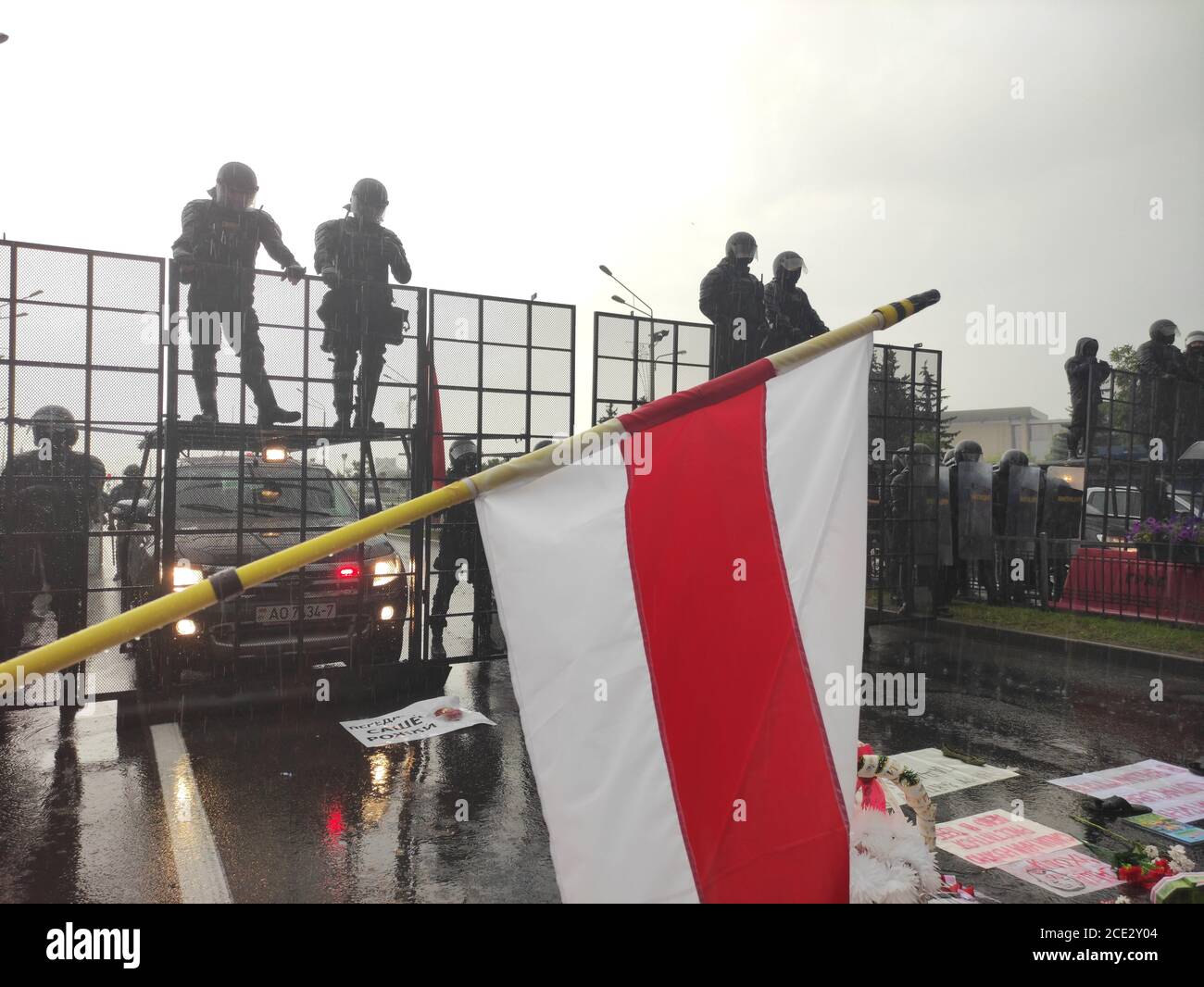 Minsk / Weißrussland - 30 2020. August: Historische weiß-rot-weiße Flagge vor der Bereitschaftspolizei blockiert die Straße für Demonstranten Stockfoto