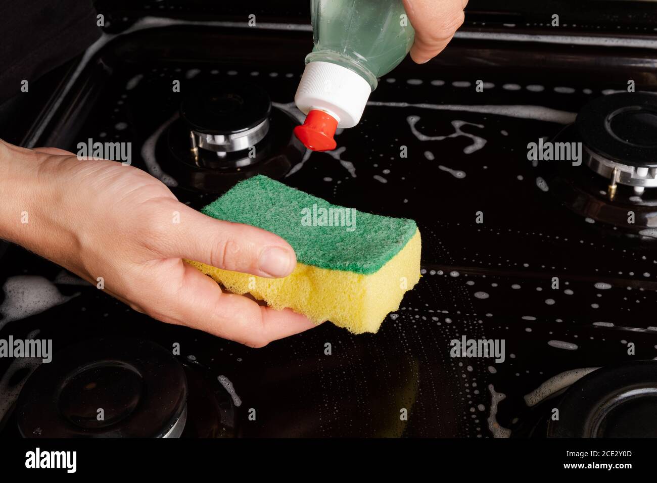 Reinigung des Gasherd mit Seifenwasser. Reinigung der Küche. Stockfoto