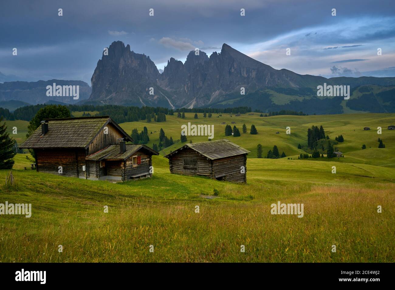 Langkofel auf der italienischen Alpen Dolomiten mit Holz Häuser im Vordergrund Stockfoto