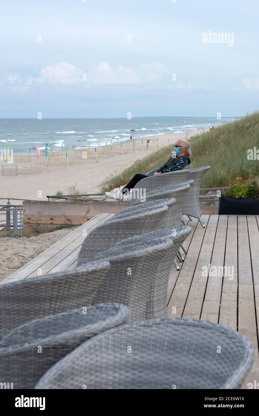 Ältere Frau mit Schutzmaske am Strand. Stockfoto