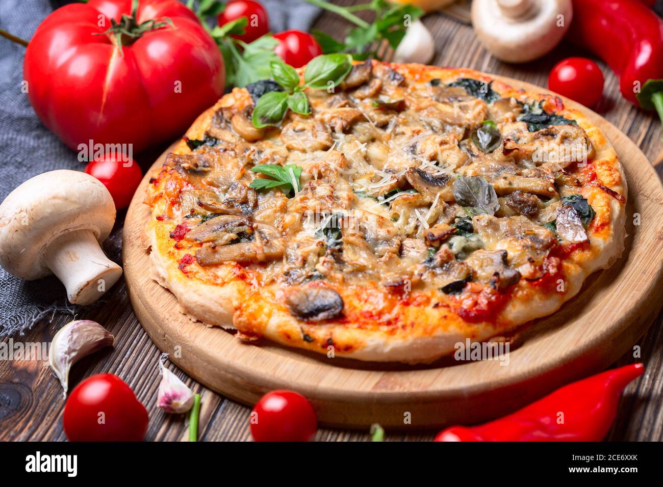 Hausgemachte Pizza mit Tomaten, Pilzen und grünem Basilikum. Stockfoto