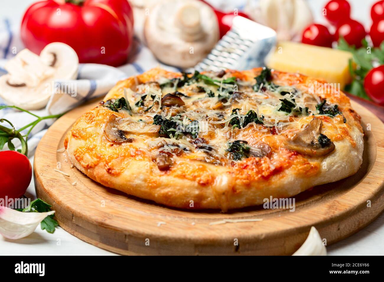 Pizza mit Tomaten, Pilzen, Käse und grünem Basilikum. Stockfoto