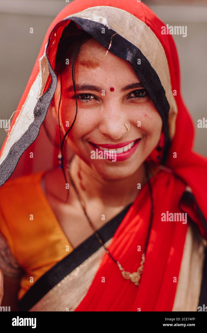 Indien - 9. November 2012: Charmante indische Frau in traditioneller Kleidung und mit Bindi auf der Stirn lächelt an der Kamera, während sie in der Stadt an sonnigen Tagen steht Stockfoto