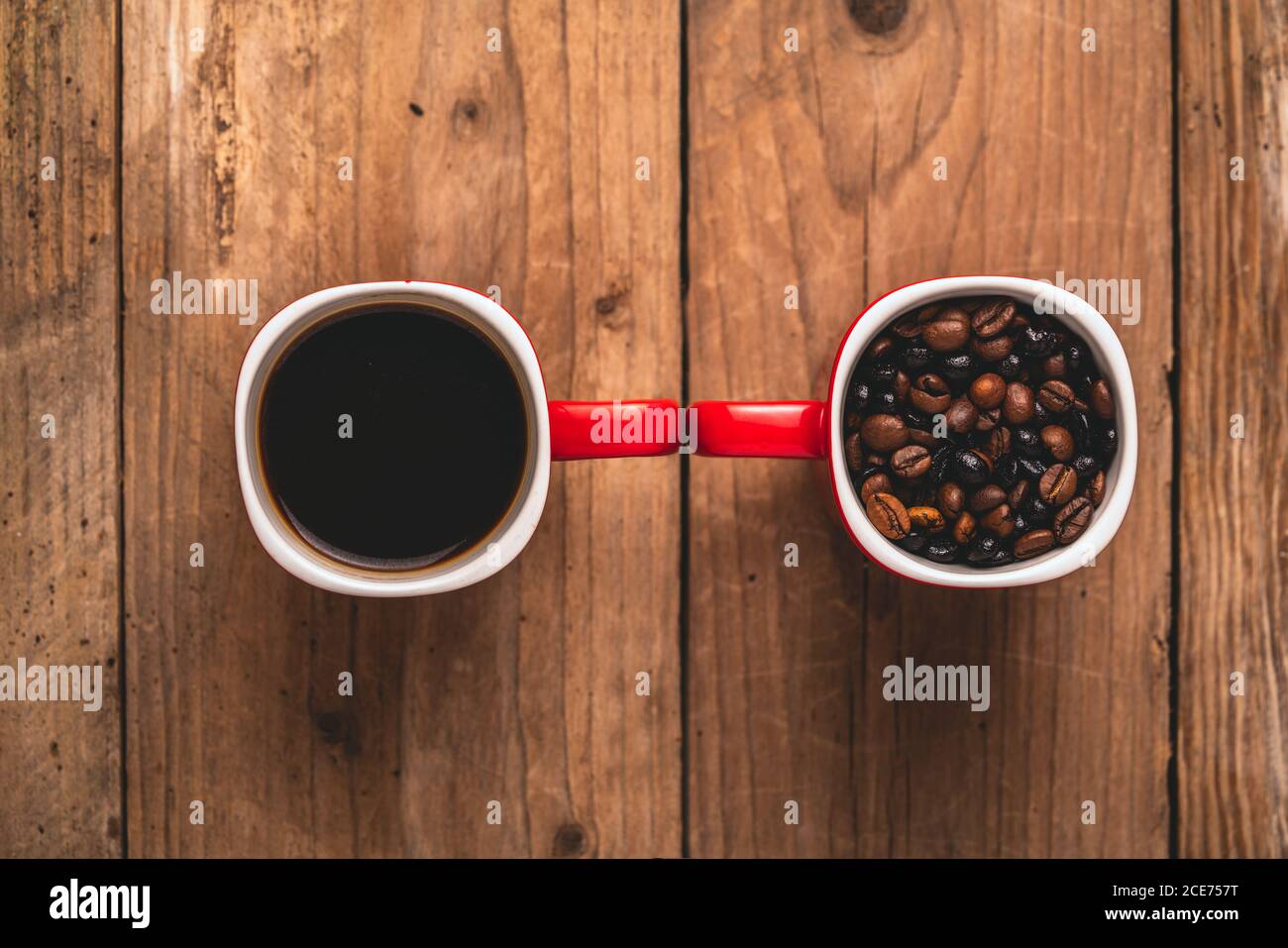 Draufsicht Komposition aus roten Tassen mit geröstetem aromatischem Kaffee Bohnen und frische heiße Energizing americano zusammen auf Holz gelegt Tabelle Stockfoto