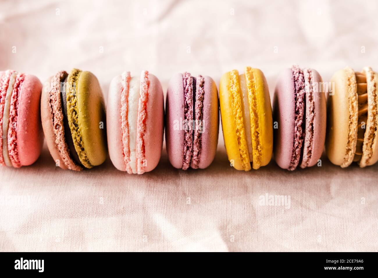 Nahaufnahme von verschiedenen köstlichen Macarons auf rosa Tisch gelegt Stockfoto