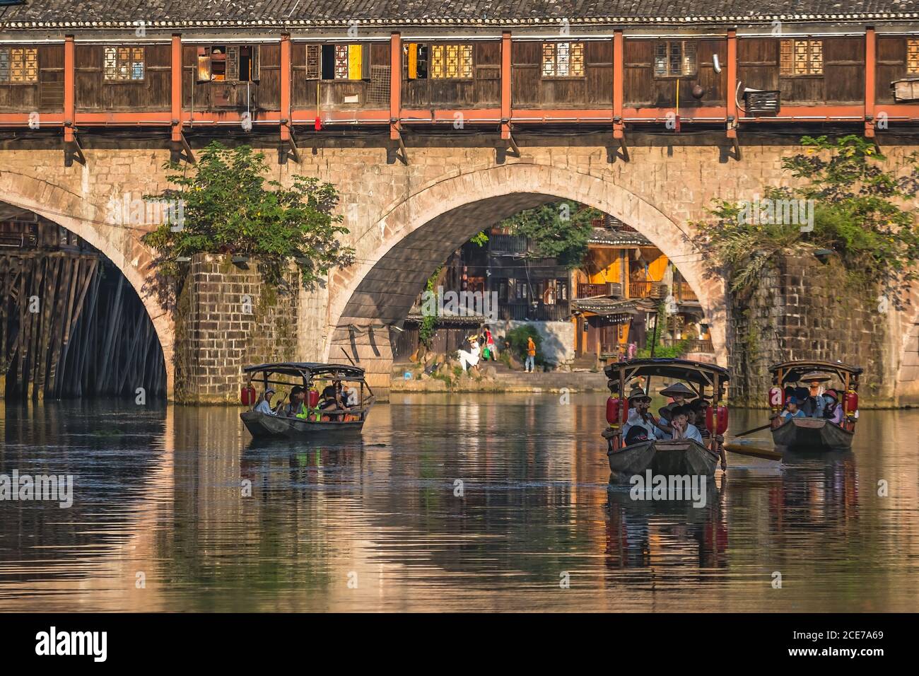 Touristenboote unter Bogenbrücke in der Feng huang Altstadt Stockfoto