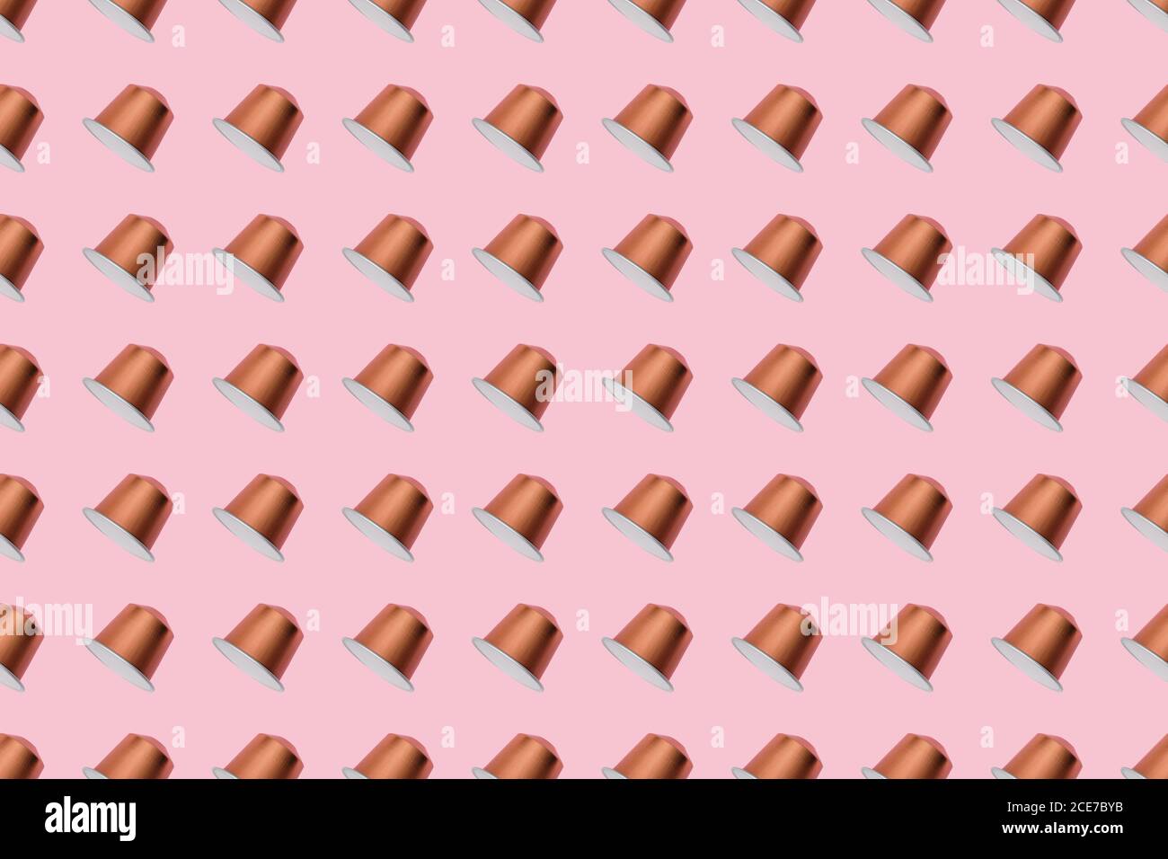 Draufsicht auf goldene Kaffeepads in geraden Reihen Als Nahtloses Muster auf rosa Hintergrund Stockfoto